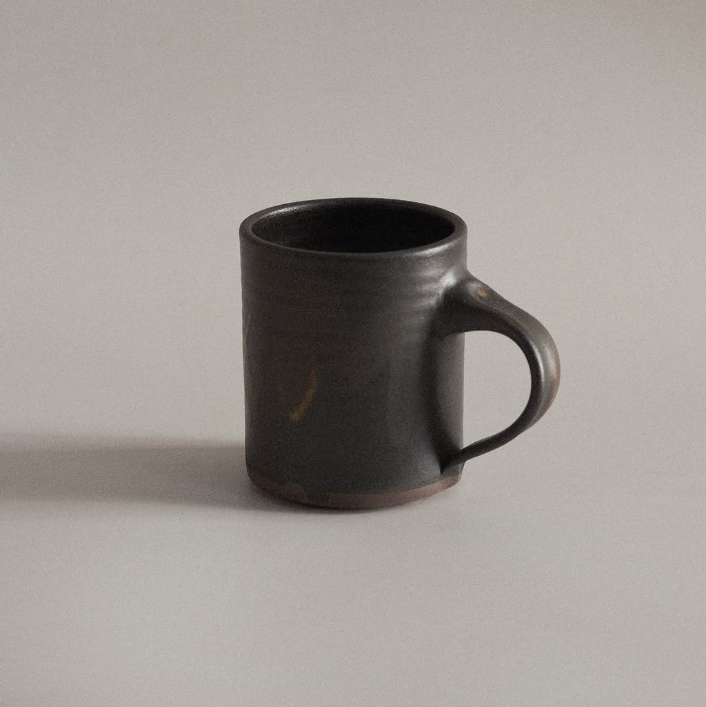 Black ceramic mug on a light gray background