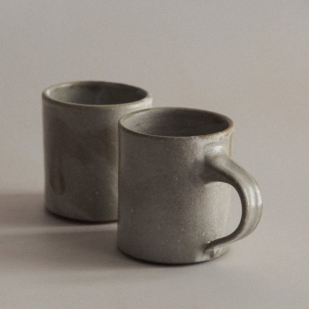 Two gray ceramic mugs on a light background