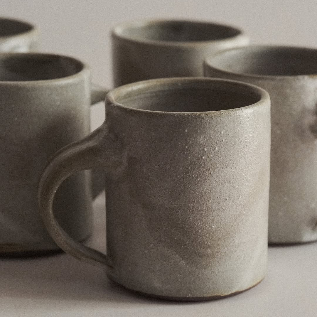 Set of gray ceramic mugs on a light background